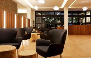 einen Wartebereich mit Stühlen und Tischen in der Lobby in der Unterkunft Golden Mar Menuda in Tossa de Mar