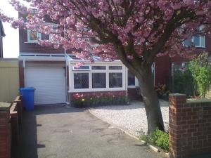 un arbre à fleurs devant une maison avec garage dans l'établissement Cherry Blossom Guest House, à Whitby