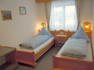 a room with two beds and a window at Landhaus Bauer in Oberstdorf