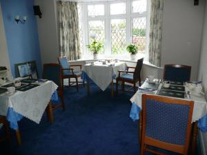 une salle à manger avec des tables et des chaises ainsi qu'une fenêtre dans l'établissement Cherry Blossom Guest House, à Whitby