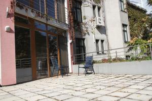 2 chaises assises sur une terrasse en face d'un bâtiment dans l'établissement Kukucinova Apartments, à Bratislava