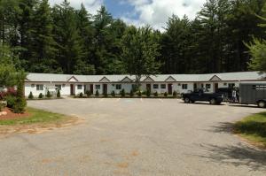 un bâtiment avec un camion garé dans un parking dans l'établissement Saco River Motor Lodge & Suites, à Center Conway