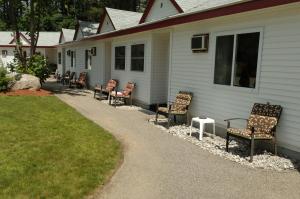 un grupo de sillas sentadas al lado de una casa en Saco River Motor Lodge & Suites, en Center Conway