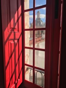 an open window with a view of a city at Casa da Sé Cathedral Suites in Coimbra