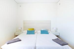 2 camas en un dormitorio con almohadas azules y amarillas en Koisi Hostel, en San Sebastián