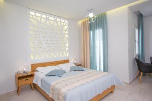 アギアアンナ・ナクソスにあるGlykeriaの白いベッドルーム(ベッド1台、窓付)