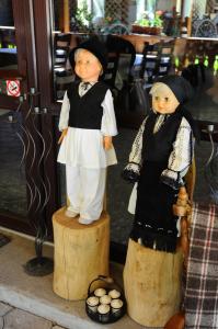 deux figurines de religieuses debout sur les poteaux en bois dans l'établissement Pensiunea Domnescu, à Sălişte