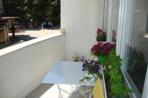 una mesa blanca y algunas flores en el balcón en Guest Rooms Colours, en Kazanlak 8 fotos más