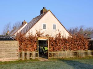 uma casa com uma cerca em frente em Cosy Holiday Home in Noordwijkerhout near Lake em Noordwijkerhout