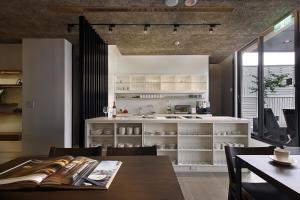 a dining room with a table and a kitchen at Laurel Villa B&B in Yuchi
