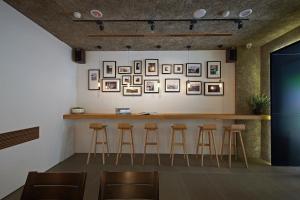 a bar with stools in a room with pictures on the wall at Laurel Villa B&B in Yuchi
