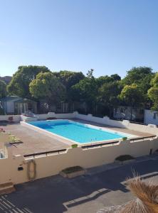 une grande piscine à côté d'un bâtiment dans l'établissement Camping la Chicanette, à Saint-Gilles