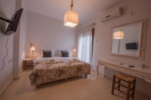 Schlafzimmer mit einem Bett, einem Spiegel und einem Schreibtisch in der Unterkunft The Beach House - Apartments & Studios in Afytos