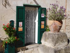 um vaso com flores sentado em frente a uma porta em B&B Fiorentini em Matera