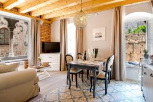 cocina y sala de estar con mesa y sillas en Heritage suites Zanini en Hvar
