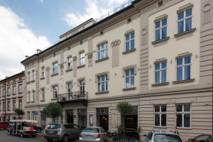 a large white building with cars parked in front of it at Apartment Greg in Krakow