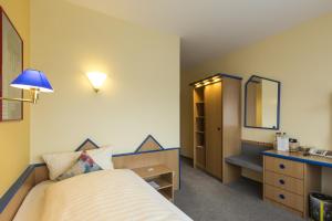Schlafzimmer mit einem Bett, einem Waschbecken und einem Spiegel in der Unterkunft Globotel Business in Garbsen
