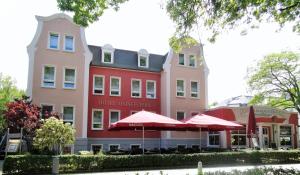 a hotel with red umbrellas in front of a building at Hotel Ostseestern in Kühlungsborn +19 photos