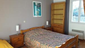 Schlafzimmer mit einem Bett, Holzmöbeln und einem Fenster in der Unterkunft Le Pas des Lanciers in Mallemort