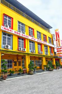 un edificio giallo con un cartello che legge cibo soosaosa di JV Hotel @ Simpang Ampat a Simpang Ampat