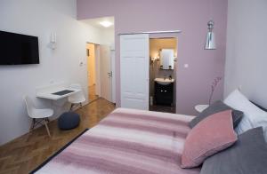 セゲドにあるDóm Apartmanのベッドルーム(大型ベッド1台付)、バスルームが備わります。