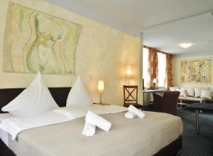 a hotel room with a large bed with white pillows at Hotel Ostseestern in Kühlungsborn