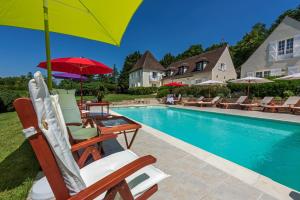 un gruppo di sedie e ombrelloni accanto alla piscina di Domaine du Bois des Anges a Germigny-lʼEvêque