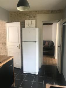 
a white refrigerator freezer sitting in a kitchen at Maison centre Bayeux 5 chambres 10 personnes in Bayeux

