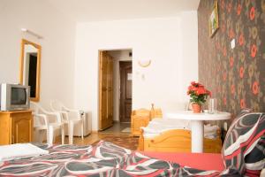 a living room with a table and a tv at Hotel Romantic in Byala