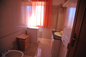 a bathroom with a sink and a toilet and a window at Palazzo Mascolo in Agerola