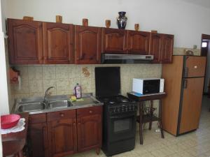 a kitchen with wooden cabinets and a stove and a sink at Apartment Via Montenegro in Ghilarza