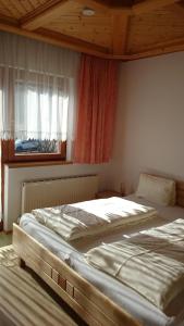 a bedroom with two beds in front of a window at Haus Alpina in Weissensee