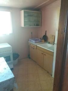 a small kitchen with a sink and a stove at Domek Letniskowy Brożówka in Kruklanki