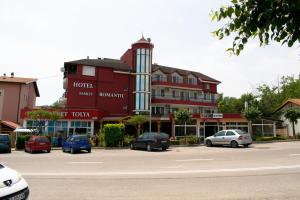 a large red building with cars parked in a parking lot at Hotel Romantic in Byala