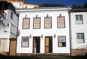 Casa blanca con ventanas y puerta en Pousada Solar Nossa Senhora Das Merces, en Ouro Preto