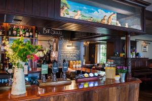 a bar with a bunch of bottles of wine at The Thomas Lord in West Meon
