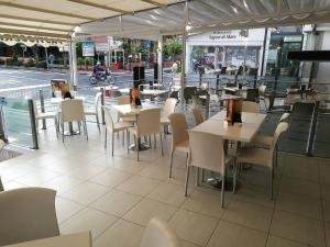ジャルディーニ・ナクソスにあるCasa Lucrezia Naxos Bayのテーブルと椅子のあるレストラン