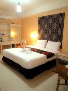 sypialnia z dużym łóżkiem z dużym zagłówkiem w obiekcie Ploy Puu Residence w mieście Chiang Rai