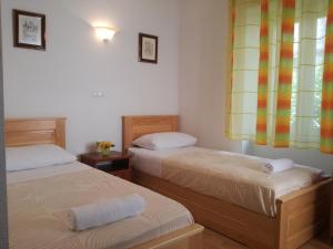 two twin beds in a room with a window at Villa Ruzica in Trogir