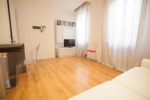 ein Wohnzimmer mit einem weißen Sofa und Holzboden in der Unterkunft Italianflat - Arena by side in Verona