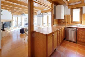 eine Küche mit Holzschränken und einer Arbeitsplatte in der Unterkunft Ribaeta by FeelFree Rentals in Vielha e Mijaran