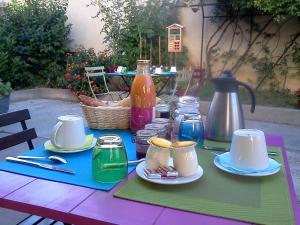 a picnic table with plates and cups and a pitcher at La Clé d'Or in Servian