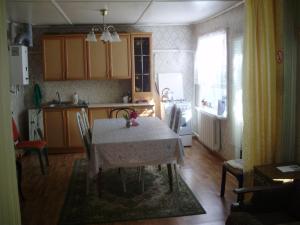 モストフスコイにあるHouse in Mostovskoyのテーブル付きのキッチン、テーブルと椅子付きのキッチン