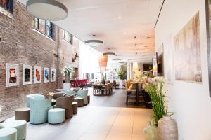 a restaurant with tables and chairs and a brick wall at Best Western Plus City Hotel Gouda in Gouda