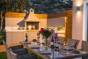 una mesa con flores y botellas de vino en el patio en Villa Crete, en Hersonissos