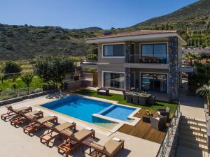 a house with a swimming pool and patio furniture at Villa Belamar in Hersonissos