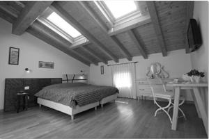 a bedroom with a bed and a desk and windows at Bed & Breakfast Ai Cracchi in Castelgomberto