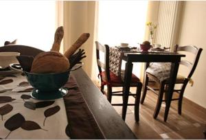 a dining room with a table with a bowl of bread and a table with at Bed & Breakfast Ai Cracchi in Castelgomberto