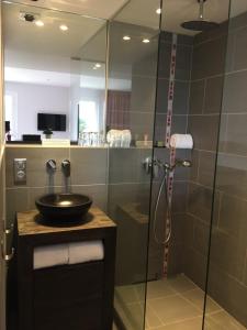 a bathroom with a shower with a sink and a mirror at Hotel-Restaurant Lann Roz / Côte Cuisine in Carnac