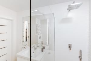 W białej łazience znajduje się wanna i przeszklony prysznic. w obiekcie Apartment No. 1 - Vento Apartamenty we Władysławowie +24 zdjęcia